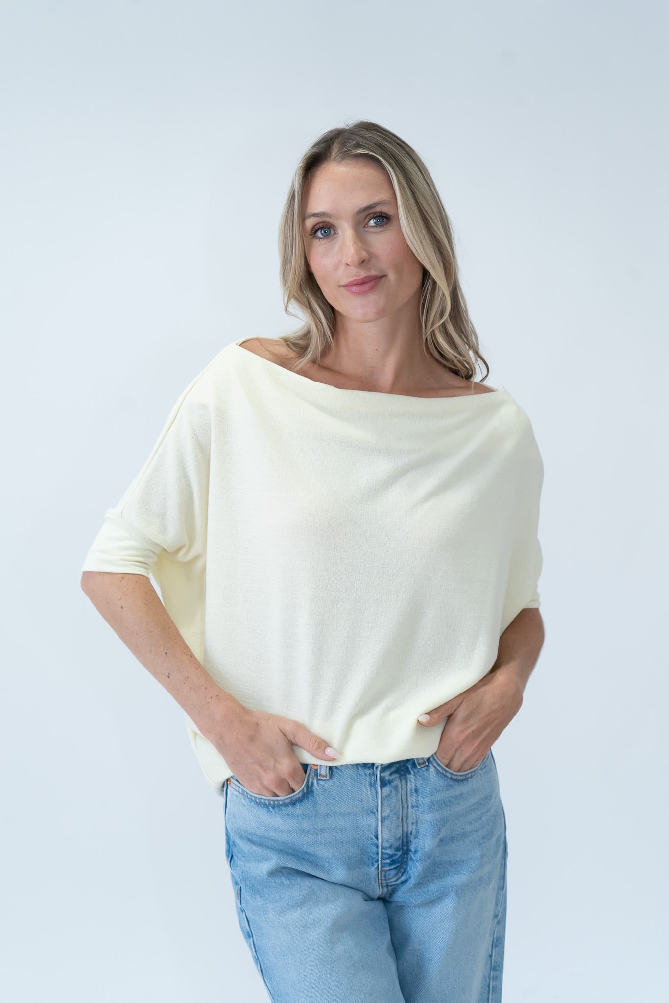 woman wearing a pale yellow off the shoulder short sleeve top.