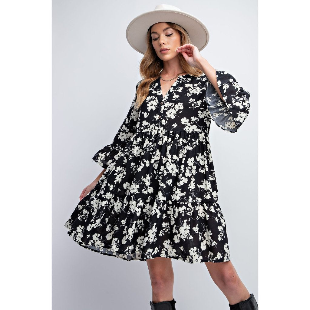 Model wearing a black and white floral swing dress.