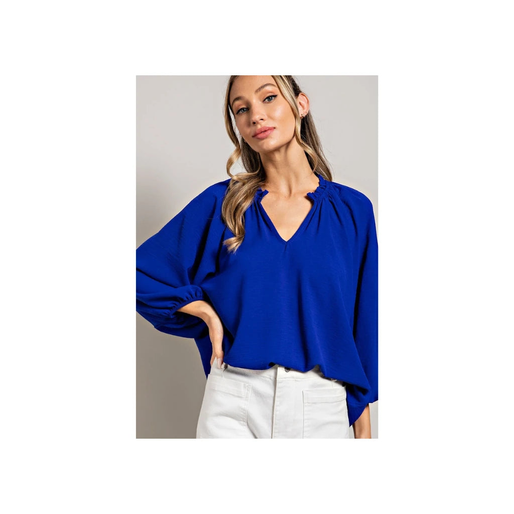 Model wearing a royal blue v neck 3/4 sleeve blouse.